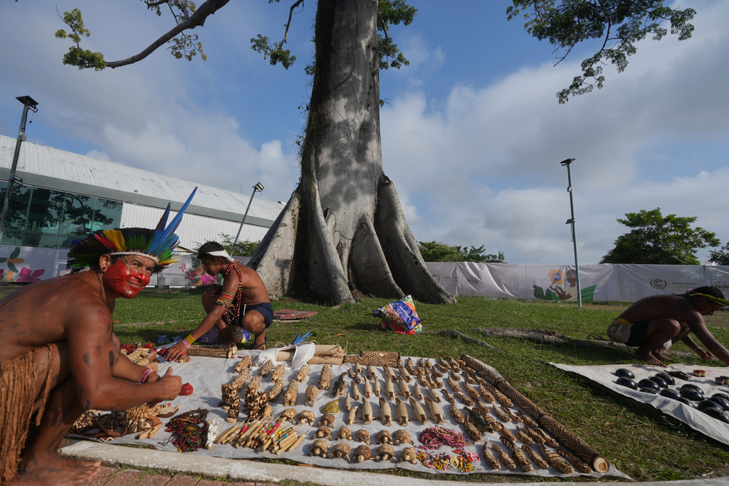 Members of an Indigenous group sell items outside the venue for the COP30 U.N. Climate Summit, Tuesday, Nov. 18, 2025, in Belem, Brazil. (AP Photo/Andre Penner)