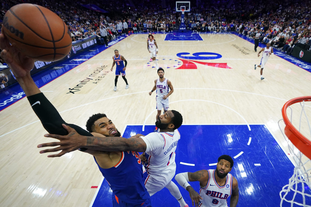 New York Knicks' Karl-Anthony Towns, left, tries to dunk against Philadelphia 76ers' Andre Drummond during the second half of Game 4 in a second-round NBA basketball playoffs series Sunday, May 10, 2026, in Philadelphia. (AP Photo/Matt Slocum)