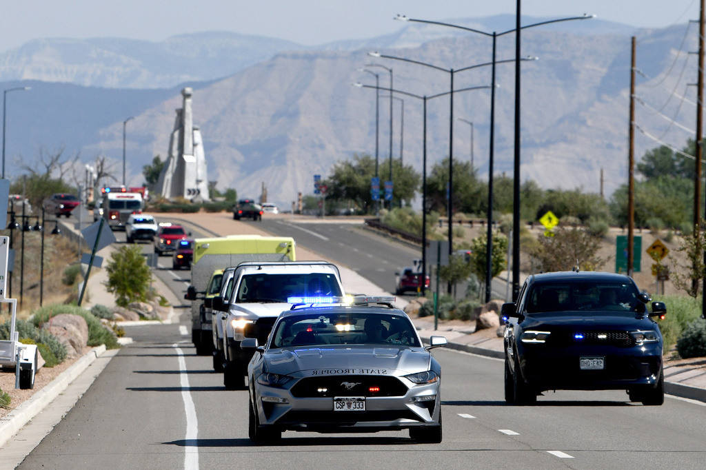 A Colorado State Patrol car leads a procession carrying the bodies of three firefighters killed while fighting the Snyder Fire in Grand Junction, Colo. Sunday, June 28, 2026. (Gretel Daugherty via AP)