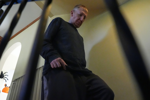 Bill Swick walks down stairs to study with his wife Martha Swick at his home in Minooka, Ill., Friday, Oct. 24, 2025. (AP Photo/Nam Y. Huh) Bill Swick walks down stairs to study with his wife Martha Swick at his home in Minooka, Ill., Friday, Oct. 24, 2025. (AP Photo/Nam Y. Huh)