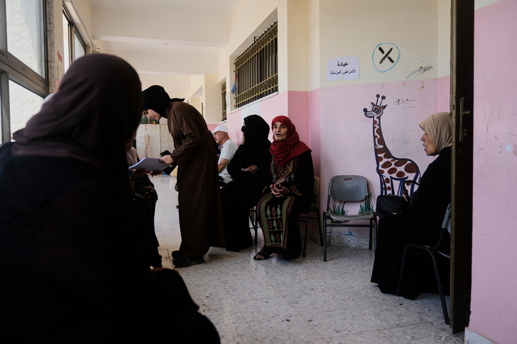Palestinian patients wait for treatment at a mobile clinic operated by Physicians for Human Rights Israel (PHRI) in the West Bank town of Iktaba, Tuesday, Aug. 4, 2026. (AP Photo/Majdi Mohammed)