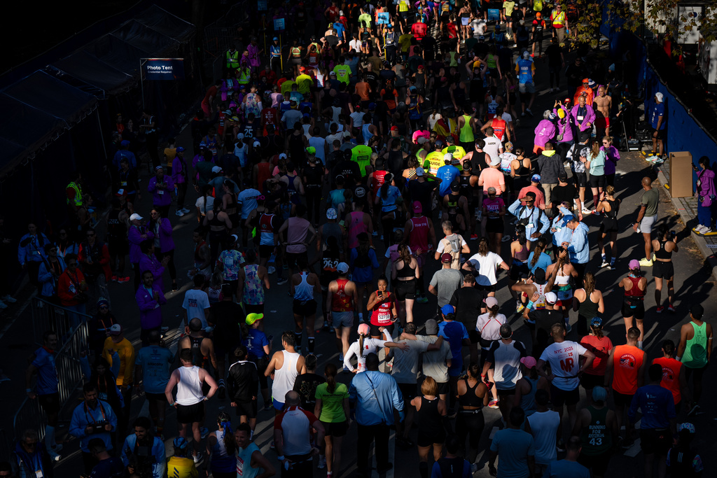 People walk and take photos after crossing the finish line of the New York City Marathon, Sunday, Nov. 2, 2025, in New York. (AP Photo/Angelina Katsanis)