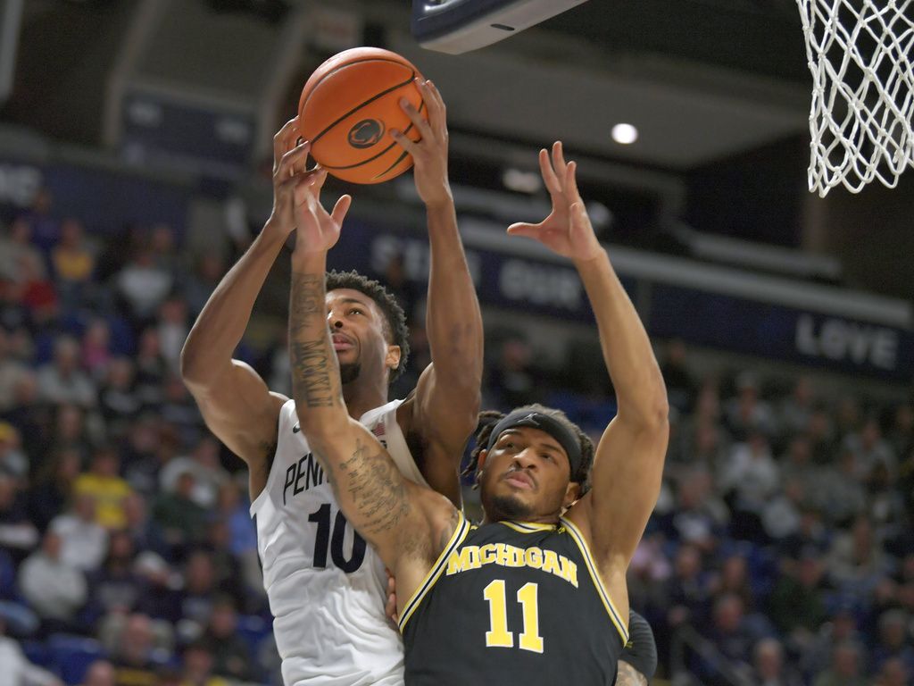 Penn State's Josh Reed (10) and Michigan's Roddy Gayle Jr. (11) battle for a rebound during the first half of an NCAA college basketball game Tuesday, Jan. 6, 2026, in State College, Pa. (AP Photo/Gary M. Baranec)