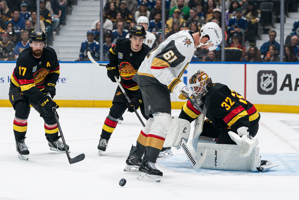 Las Vegas Golden Knights' Mark Stone (61) looks for the puck after Vancouver Canucks goalie Kevin Lankinen (32) made a save during the first period of an NHL hockey game in Vancouver, British Columbia, Sunday, Oct. 4, 2026. (Rich Lam/The Canadian Press via AP)