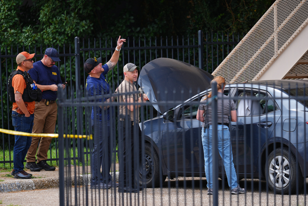 A law enforcement agents search a vehicle near the scene of a shooting at a U.S. Immigration and Customs Enforcement office in Dallas on Wednesday, Sept. 24, 2025. (AP Photo/Julio Cortez)
