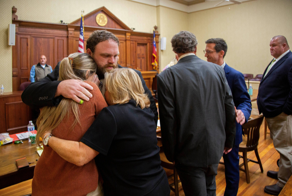 Rhett Scott hugs his wife Kelly Scott, left, and his mother Karen Scott, right, after being found not guilty of felony murder in the 2017 death of Eurie Martin on Thursday, Nov. 20, 2025 in Sandersville, Ga. (Grant Blankenship/Georgia Public Broadcasting via AP)