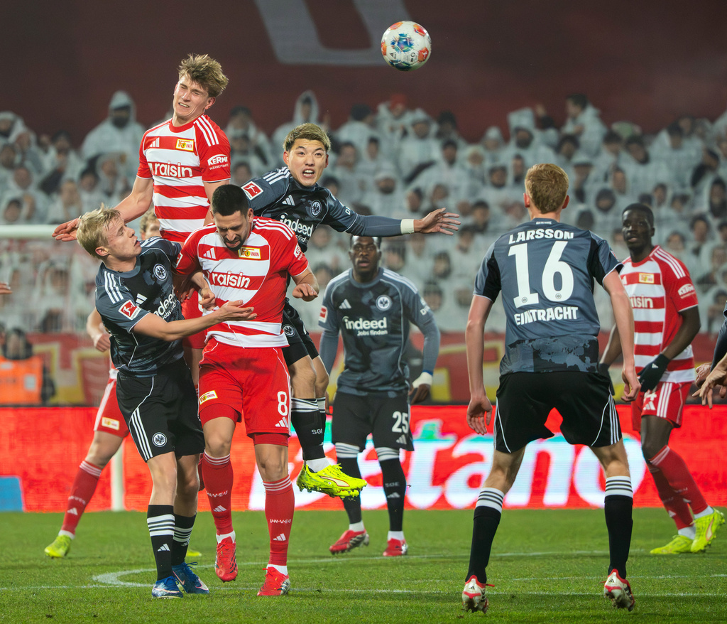 Union Berlin's Aljoscha Kemlein, top left, and Eintracht Frankfurt's Ritsu Doan, top center, battle for a head ball during a Bundesliga soccer match, Friday, Feb. 6, 2026, in Berlin. (Soeren Stache/dpa via AP)