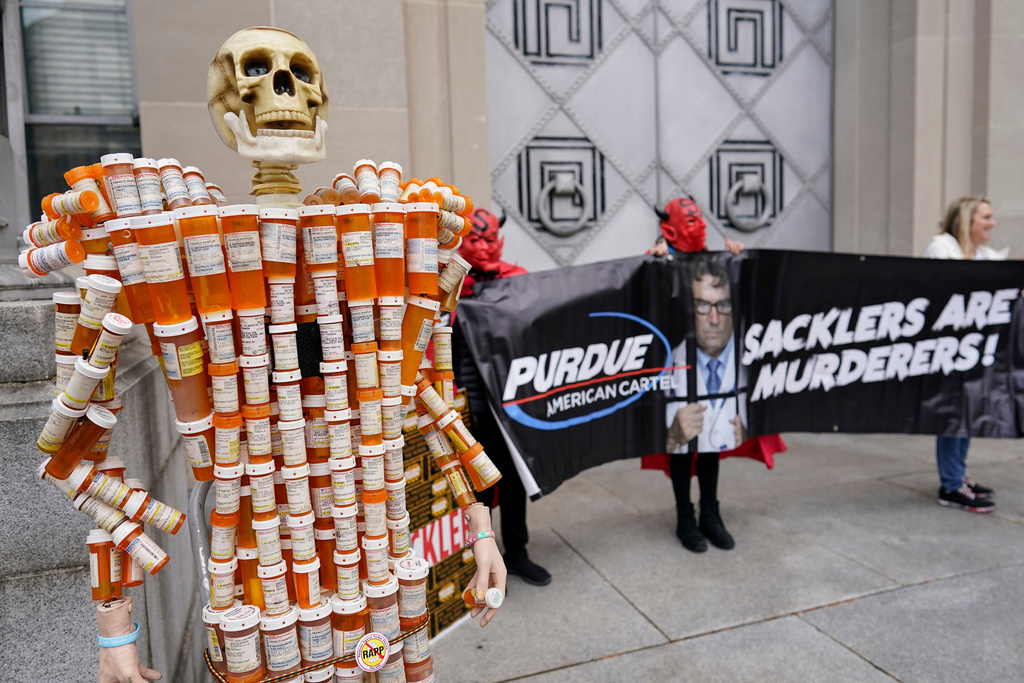 FILE - "Pill Man" made by Frank Huntley of Worcester, Mass., from his opioid prescription pill bottles, is displayed during a protest by advocates for opioid victims outside the Department of Justice, Dec. 3, 2021, in Washington. (AP Photo/Carolyn Kaster, File)