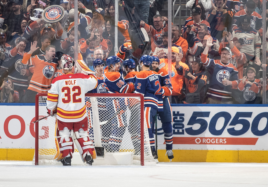 Calgary Flames goalie Dustin Wolf (32) looks on as Edmonton Oilers players celebrate a goal during first period NHL action, in Edmonton on Wednesday, Oct. 8, 2025. (Jason Franson/The Canadian Press via AP)