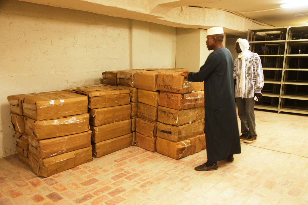 Abdoulaye Cissé, Left, an employee of the Ahmed Baba Institute of Higher Islamic Studies and Research, inspects crates containing manuscripts in Timbuktu, Mali, Sept. 4, 2025. (AP Photo/Baba Ahmed)