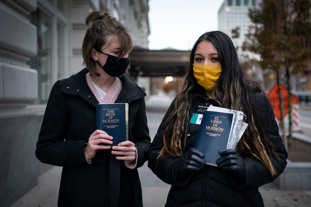 FILE - Sister Palmer 19, right, and Sister Raymundo pose for a portrait with The Book of Mormon while walking around Temple Square in Salt Lake City on Nov. 15, 2020. (AP Photo/Wong Maye-E, File)