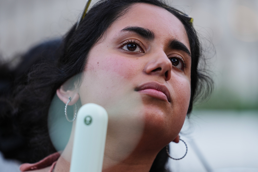 FILE - Meghana Jalagam uses a fan to keep cool from the hot weather during a World Cup soccer match between the United States and Bosnia and Herzegovina at a watch party July 1, 2026, in Detroit. (AP Photo/Paul Sancya, File)