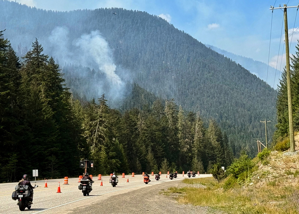 Fire crews drop water on a wildfire along Highway 3 in Manning Park, British Columbia, as fires burn throughout the southeastern part of the province on Wednesday, Aug. 12, 2026. (AP Photo/Haven Daley)