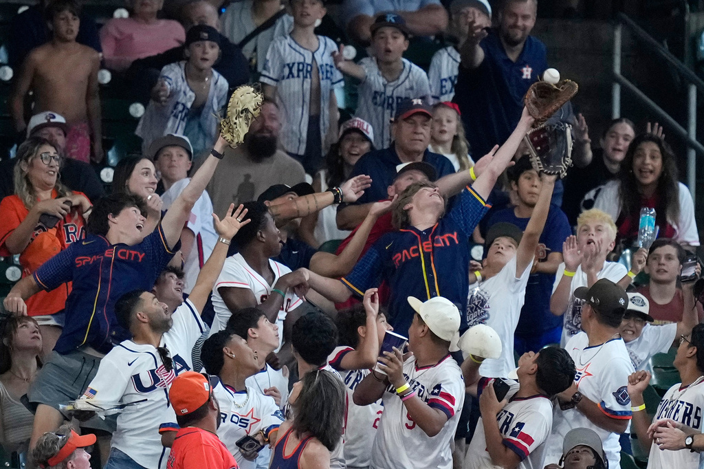 Fans reach for a foul ball hit by Houston Astros' Jose Altuve during the fifth inning of a baseball game against the Detroit Tigers, Wednesday, June 17, 2026, in Houston. (AP Photo/Kevin M. Cox)
