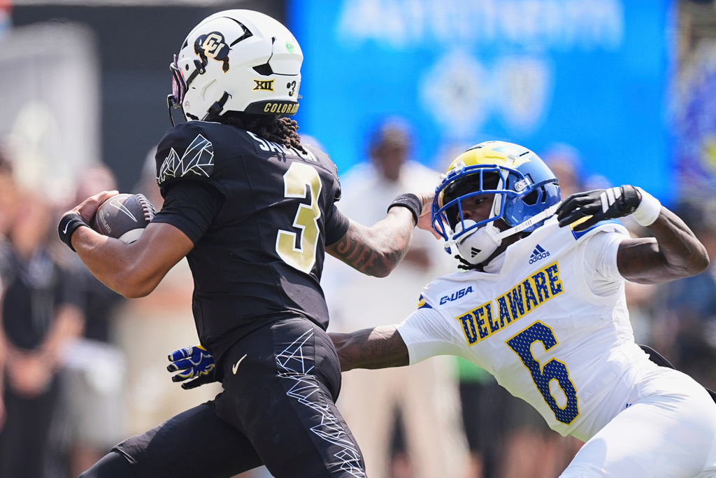 Colorado quarterback Kaidon Salter, left, eludes Delaware cornerback Kshawn Cox Jr. for a short gain in the first half of an NCAA college football game Saturday, Sept. 6, 2025, in Boulder, Colo. (AP Photo/David Zalubowski)