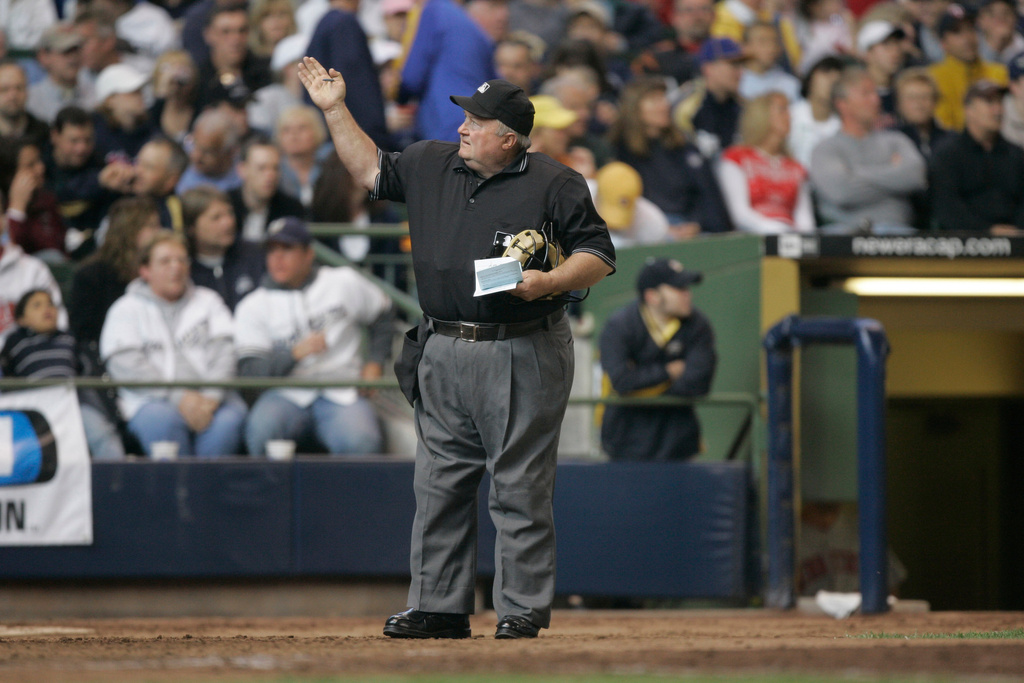 FILE - Home plate umpire Bruce Froemming signals to the official scorer during the fifth inning of a baseball game May 20, 2007, in Milwaukee. (AP Photo/Morry Gash, File)
