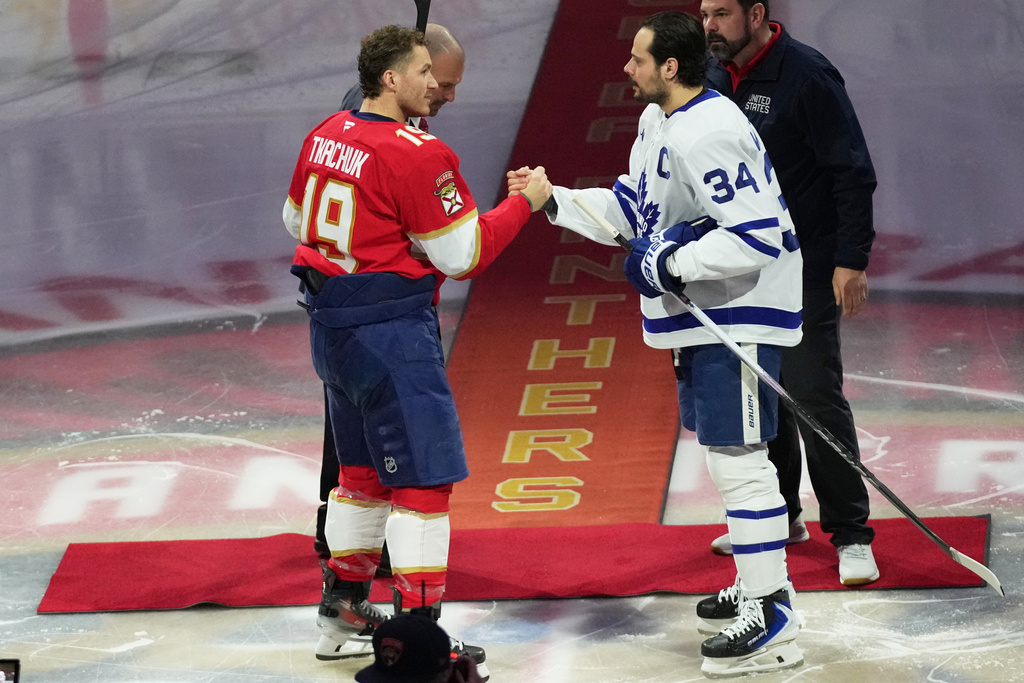 Florida Panthers left wing Matthew Tkachuk (19) and Toronto Maple Leafs center Auston Matthews (34) shake hands before an NHL hockey game honoring the players on the USA team winning the gold medal at the Milan Cortina Olympics, Thursday, Feb. 26, 2026, in Sunrise, Fla. (AP Photo/Lynne Sladky)