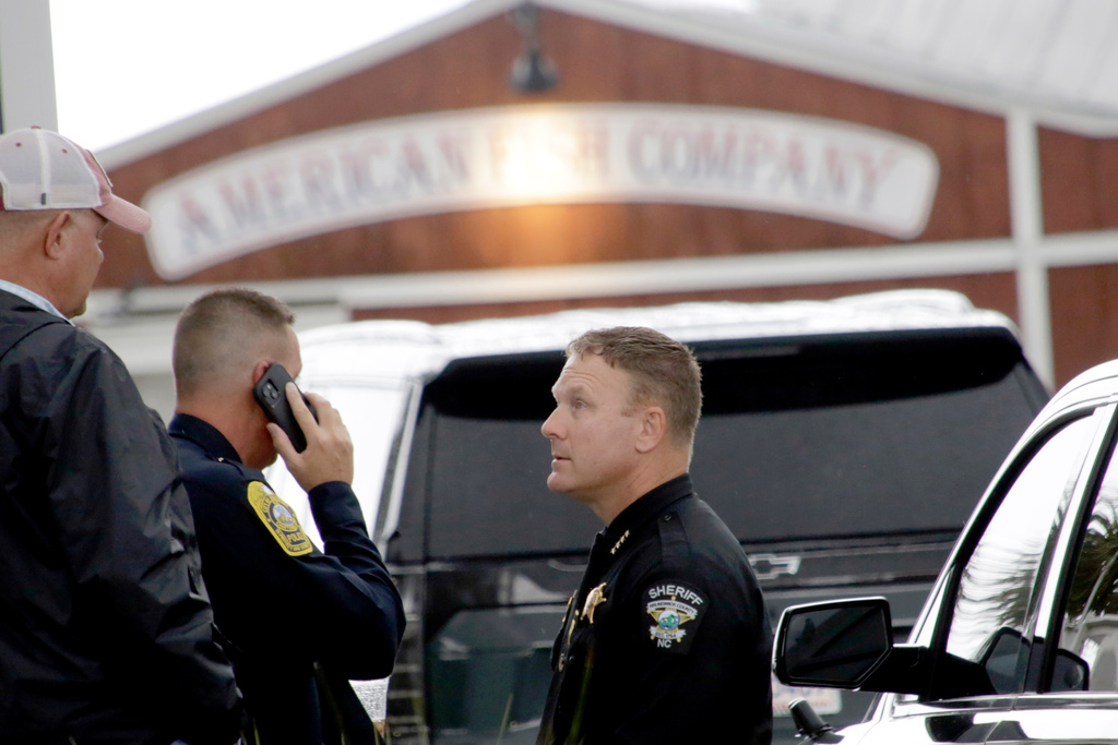 Police officers on the scene in front of the American Fish Company following a fatal shooting that occurred here the night before, Sunday, Sept. 28, 2025, in Southport, N.C. (AP Photo/Chris Seward)
