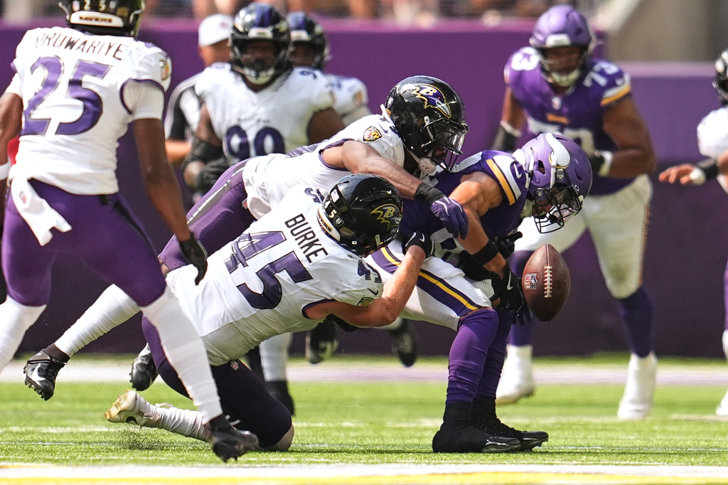 Minnesota Vikings wide receiver Jeshaun Jones, right, fumbles the ball as he is tackled by Baltimore Ravens linebackers Jay Higgins IV, above, and Ethan Burke (45) during the second half of an NFL preseason football game, Saturday, Aug. 22, 2026, in Minneapolis. (AP Photo/Abbie Parr)