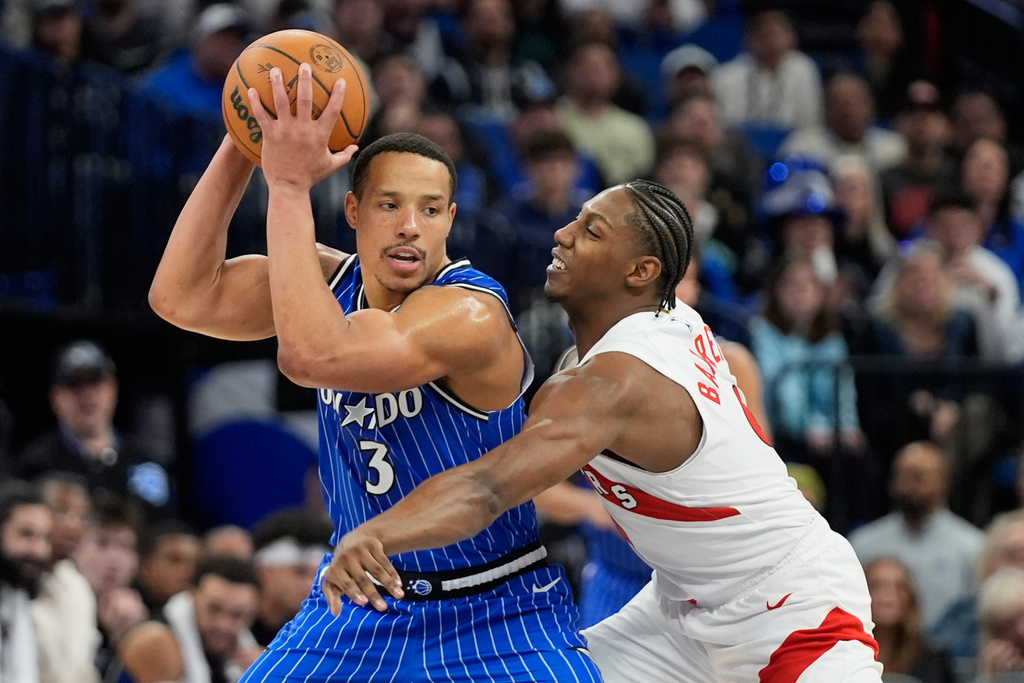 Orlando Magic guard Desmond Bane (3) tries to get past Toronto Raptors forward RJ Barrett, right, during the second half of an NBA basketball game, Friday, Jan. 30, 2026, in Orlando, Fla. (AP Photo/John Raoux)