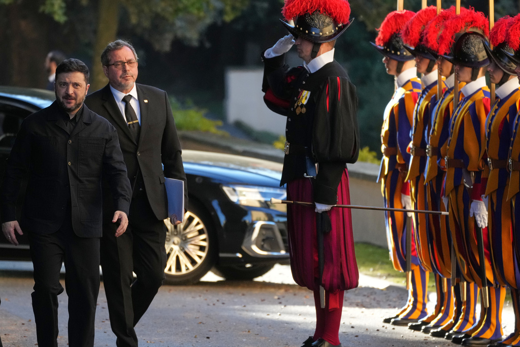 Ukraine President Volodymyr Zelenskyy, left, walks past Swiss guards as he arrives to meet with Pope Leo XIV in Castel Gandolfo, Italy, Tuesday, Dec. 9, 2025. (AP Photo/Andrew Medichini)