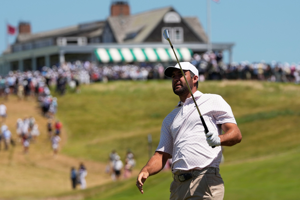 Scottie Scheffler watches his shot on the first hole during the third round of the U.S. Open golf tournament at Shinnecock Hills Golf Club in Southampton, N.Y., Saturday, June 20, 2026.(AP Photo/David J. Phillip)