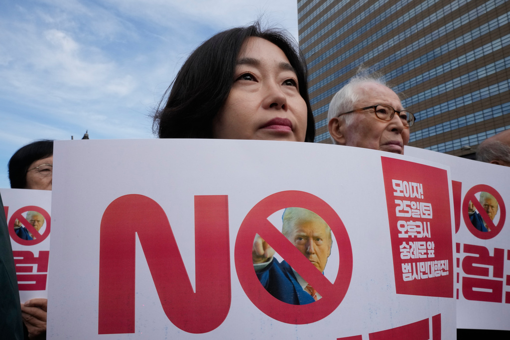South Korean protesters attend a rally against U.S. President Donald Trump's tariffs policy on South Korea, near the U.S. Embassy in Seoul, South Korea, Tuesday, Oct. 21, 2025. (AP Photo/Ahn Young-joon)