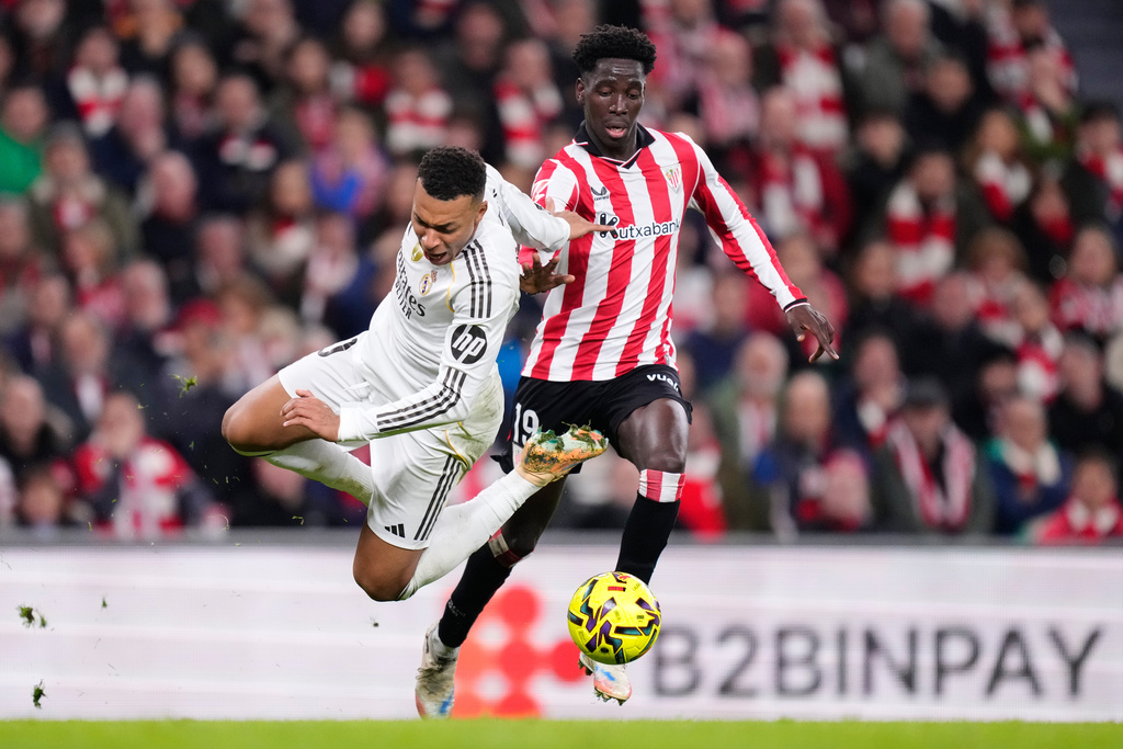 Real Madrid's Kylian Mbappe, left, challenges for the ball with Athletic Bilbao's Adama Boiro during the Spanish La Liga soccer match between Athletic Bilbao and Real Madrid in Bilbao, Spain, Wednesday, Dec. 3, 2025. (AP Photo/Jose Breton)