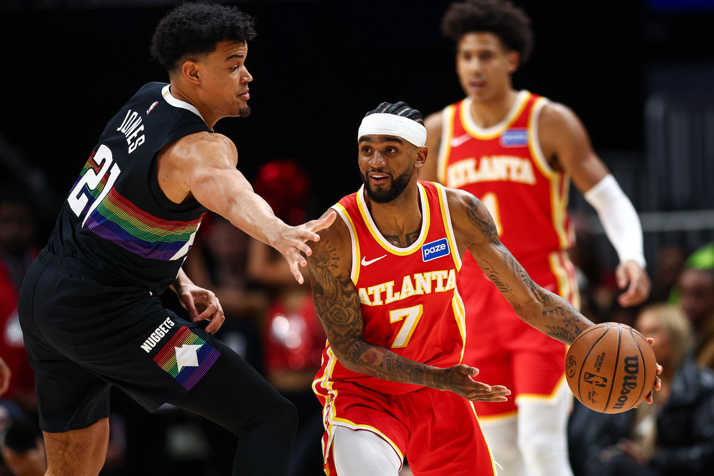 Atlanta Hawks guard Nickeil Alexander-Walker (7) looks to pass the ball defended by Denver Nuggets forward Spencer Jones, left, during the first half of an NBA basketball game, Friday, Dec. 5, 2025, in Atlanta. (AP Photo/Colin Hubbard)