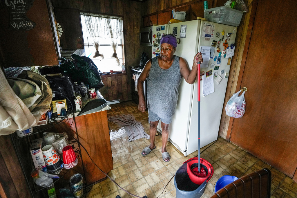 Bendy Lee, 72, mops up water in her kitchen after a tree fell on her roof, causing rain to come inside, in the aftermath of Tropical Storm Edouard in Kountze, Texas, Wednesday, Sept. 2, 2026. (Brett Coomer/Houston Chronicle via AP)