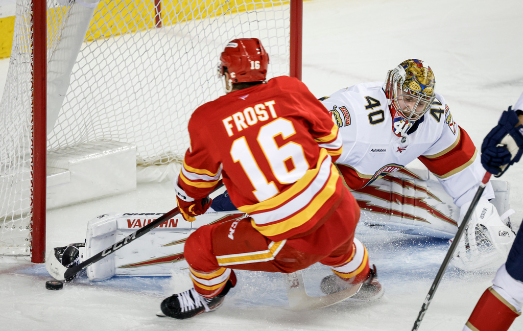 Florida Panthers goalie Daniil Tarasov (40) kicks the puck away from Calgary Flames' Morgan Frost (16) during first-period NHL hockey game action in Calgary, Alberta, Friday, March 20, 2026. (Jeff McIntosh/The Canadian Press via AP)