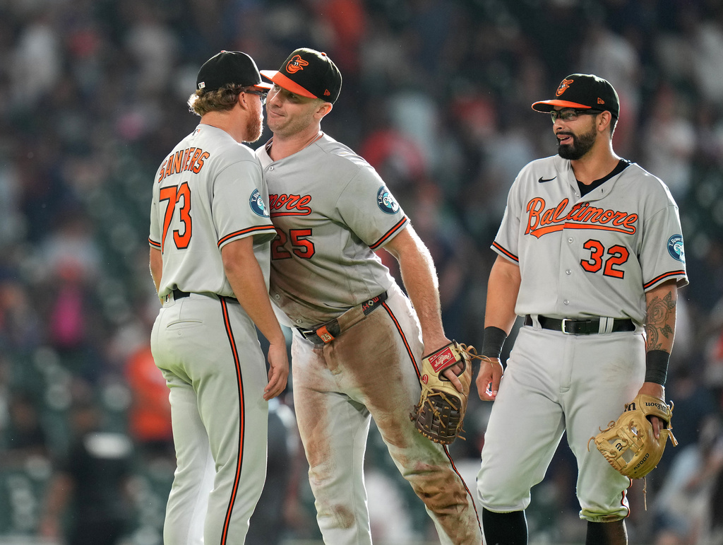 Baltimore Orioles relief pitcher Cam Sanders, left, celebrates with Pete Alonso, center, and Christian Encarnacion-Strand, right, after a baseball game against the Houston Astros, Saturday, July 18, 2026, in Houston. (AP Photo/Karen Warren)