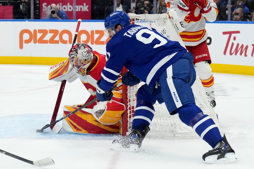 Toronto Maple Leafs forward John Tavares (91) gets stopped on a wraparound attempt by Calgary Flames goaltender Dustin Wolf (32) during second period NHL hockey action in Toronto, Tuesday, Oct. 28, 2025. (Nathan Denette/The Canadian Press via AP) Toronto Maple Leafs forward John Tavares (91) gets stopped on a wraparound attempt by Calgary Flames goaltender Dustin Wolf (32) during second period NHL hockey action in Toronto, Tuesday, Oct. 28, 2025. (Nathan Denette/The Canadian Press via AP)