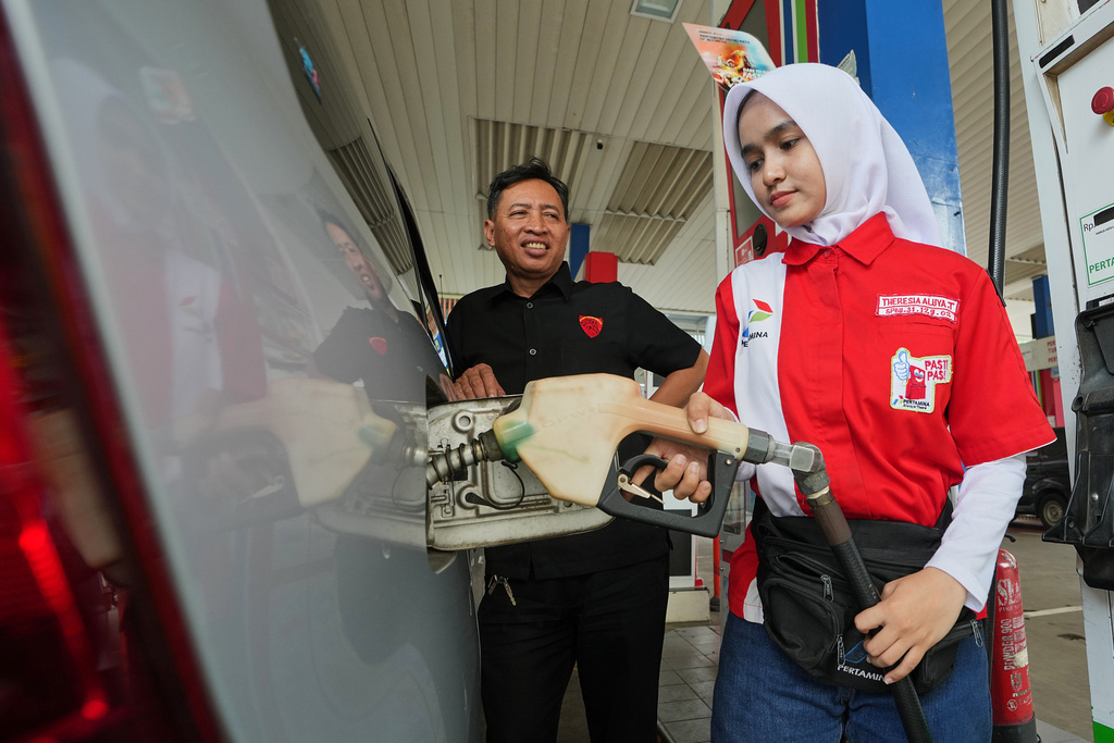 An employee fills fuel in a car at a gas station in Jakarta, Indonesia, Tuesday, March 3, 2026. (AP Photo/Achmad Ibrahim)