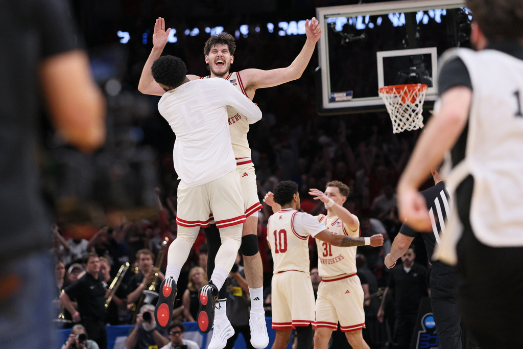 Nebraska forward Berke Buyuktuncel, facing the camera, leaps into the arms of a teammate after a game against Vanderbilt in the second round of the NCAA college basketball tournament, Saturday, March 21, 2026, in Oklahoma City, Okla. (AP Photo/Nate Billings)