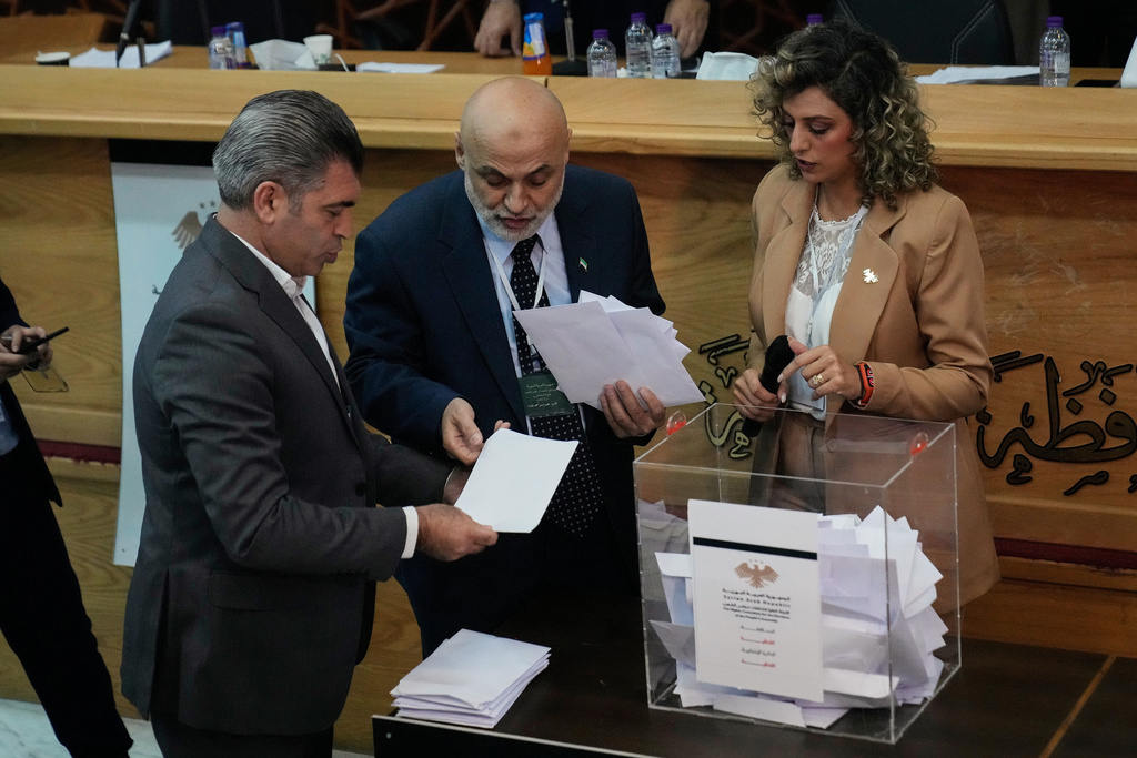 Syrian election officials count ballots shortly after polling stations closed at Latakia's Governor building, in the coastal city of Latakia, Syria, Sunday, Oct. 5, 2025. (AP Photo/Hussein Malla)
