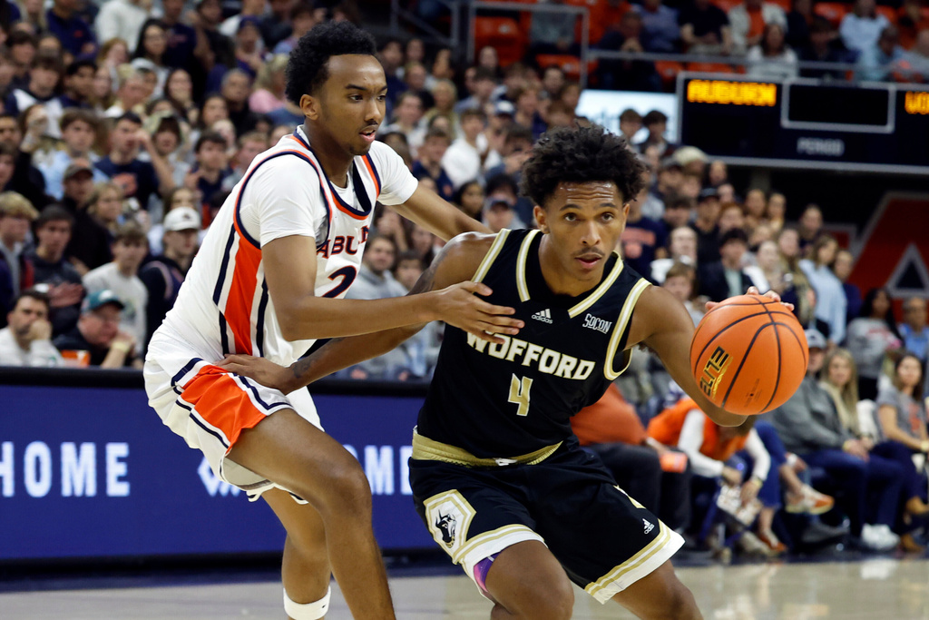 Wofford guard Chace Watley (4) drives to the basket around Auburn guard Abdullahi Bashir (2) during the first half of an NCAA college basketball game, Tuesday, Nov. 11, 2025, in Auburn, Ala. (AP Photo/Butch Dill)