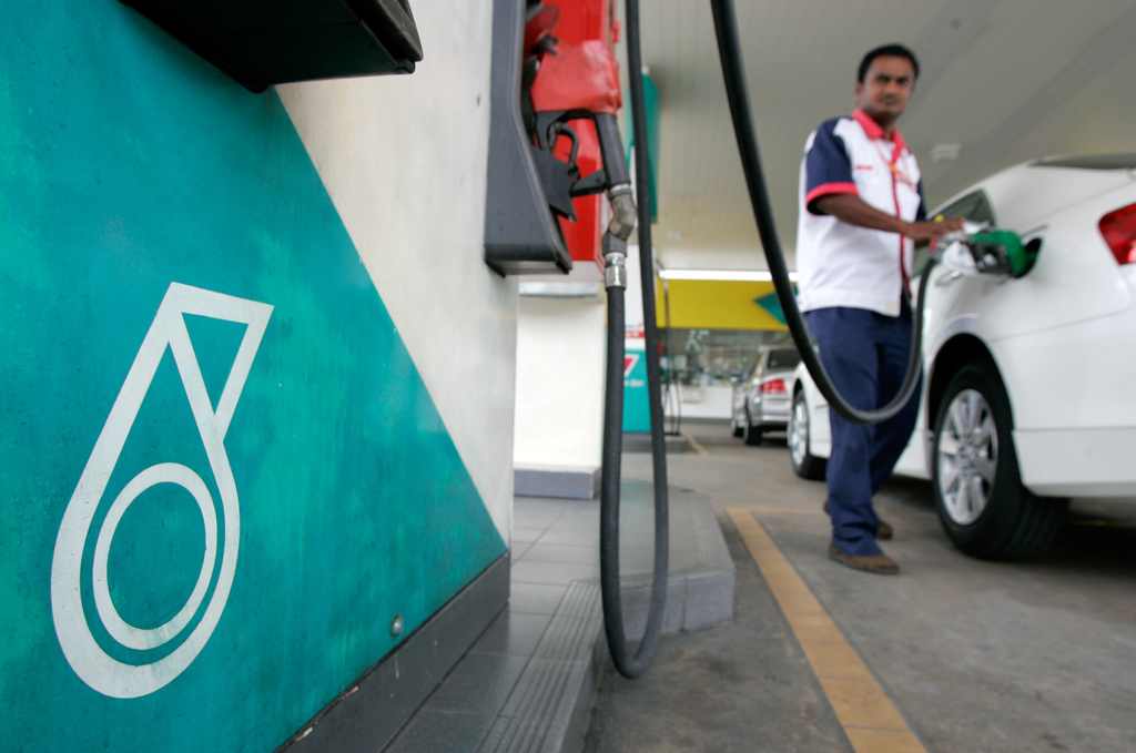 FILE -A Malaysian motorist pumps his vehicle with gasoline at Petronas petrol station in Kuala Lumpur, Malaysia, July, 15, 2008. (AP Photo/Lai Seng Sin, File)