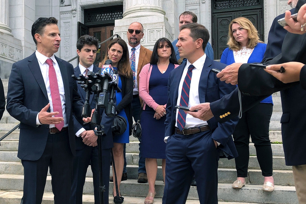 FILE - Attorneys Joshua Koskoff, left, and Christopher Mattei, right, representing parents, rear, of children killed in the 2012 Sandy Hook Elementary School shooting, speak outside the Connecticut Supreme Court, Sept. 26, 2019, in Hartford, Conn. (AP Photo/Dave Collins, File)