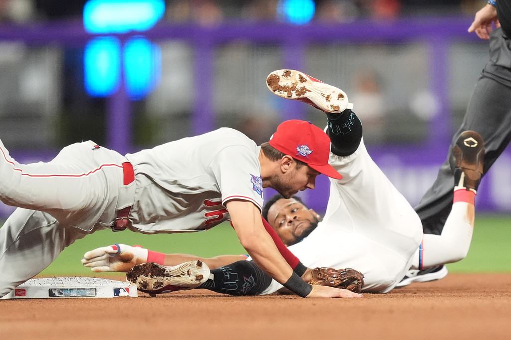 Philadelphia Phillies shortstop Trea Turner, left, gets out Miami Marlins' Otto Lopez as he attempts to steal second during the fourth inning of a baseball game, Monday, May 4, 2026, in Miami. (AP Photo/Rebecca Blackwell)