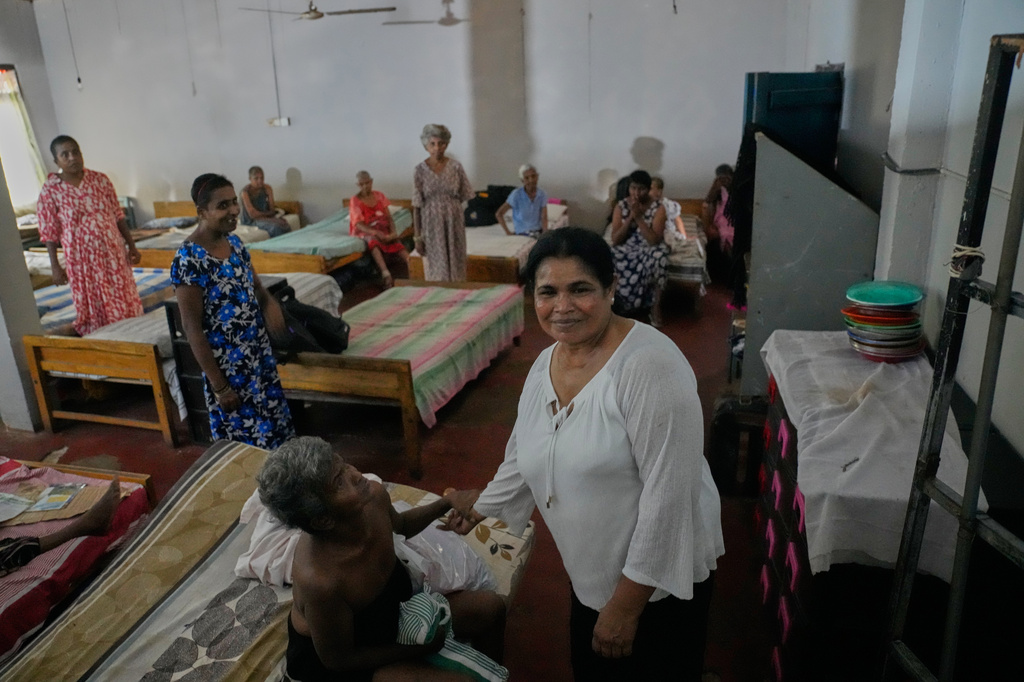 Residents interact with Amala Rajapaksa, the administrator of the nursing home, where inmates of another nursing home that caught fire on Wednesday are being temporarily housed in Anguruwatota, Sri Lanka, Friday, June 5, 2026. (AP Photo/Eranga Jayawardena)