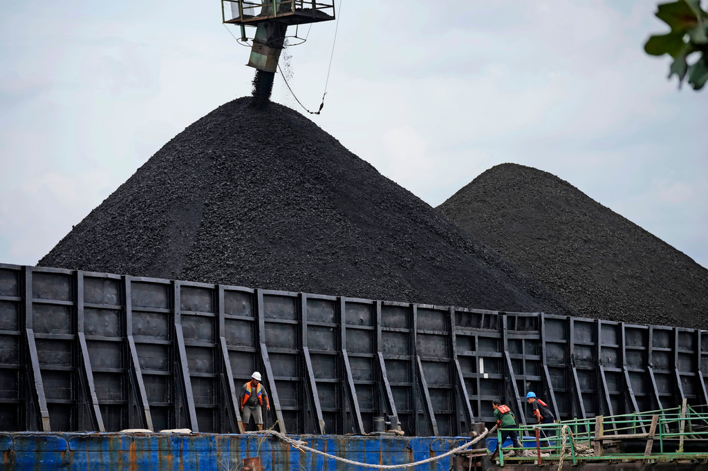 FILE - Workers check the rope on a barge as it's being loaded with coal in Kutai Kartanegara, East Kalimantan, Indonesia, Tuesday, Dec. 20, 2022. Indonesia. (AP Photo/Dita Alangkara, File)