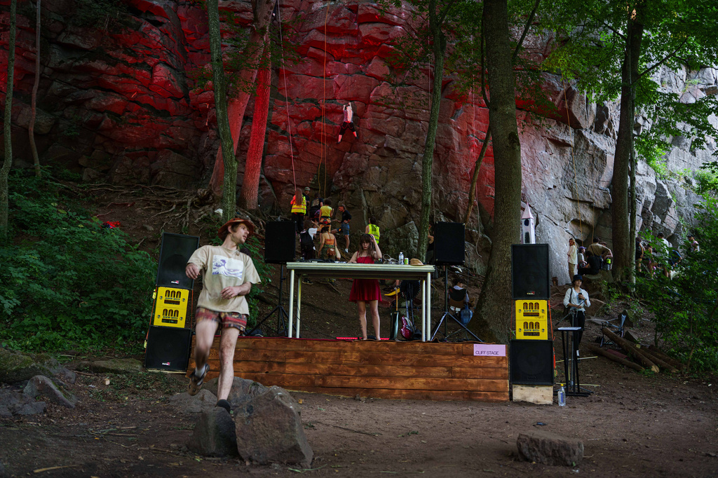 A woman plays a dj set during the Stoned Climbers festival near Denyshi, Zhytomyr region, Ukraine, Saturday, June 27, 2026. (AP Photo/Evgeniy Maloletka)