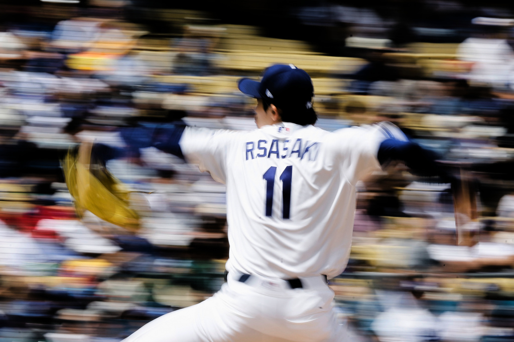 Los Angeles Dodgers starting pitcher Roki Sasaki (11) pitches during the first inning of a baseball game against the Texas Rangers, Sunday, April 12, 2026, in Los Angeles. (AP Photo/Caroline Brehman)