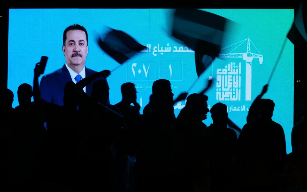 Iraqi Prime Minister Mohammed Shia al-Sudani is displayed on a screen as supporters celebrate following the announcement of the results of the parliamentary elections in Tahrir Square, Baghdad, Iraq, Wednesday, Nov. 12, 2025. (AP Photo/Hadi Mizban)