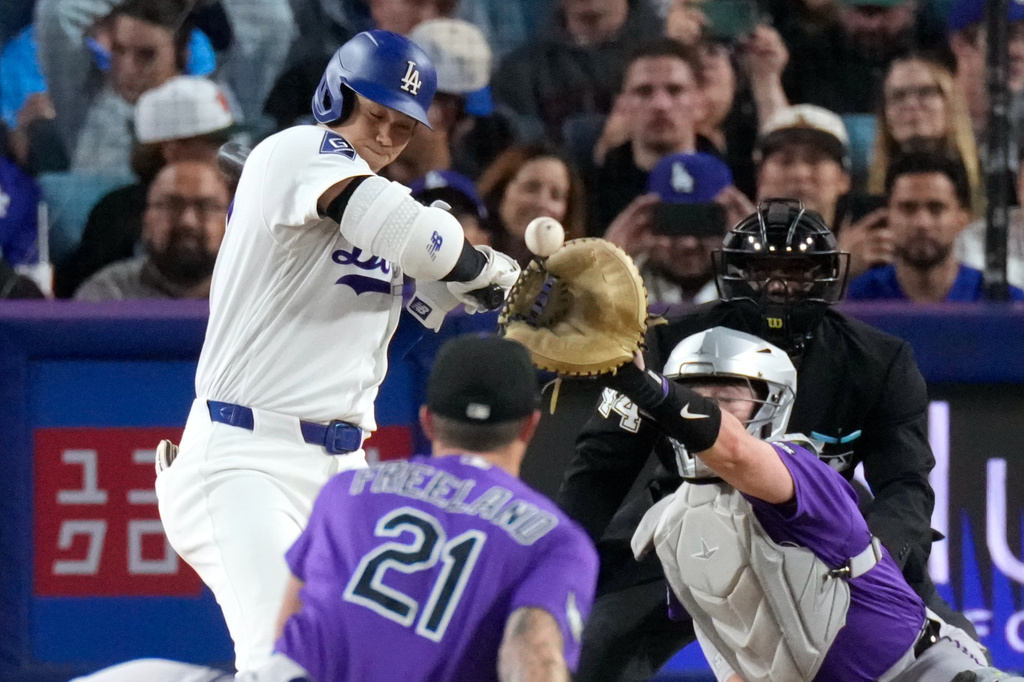 Los Angeles Dodgers' Shohei Ohtani, left, is hit by a pitch as Colorado Rockies pitcher Kyle Freeland, second from left, and catcher Hunter Goodman watch during the fourth inning of a baseball game Tuesday, May 26, 2026, in Los Angeles. (AP Photo/Mark J. Terrill)