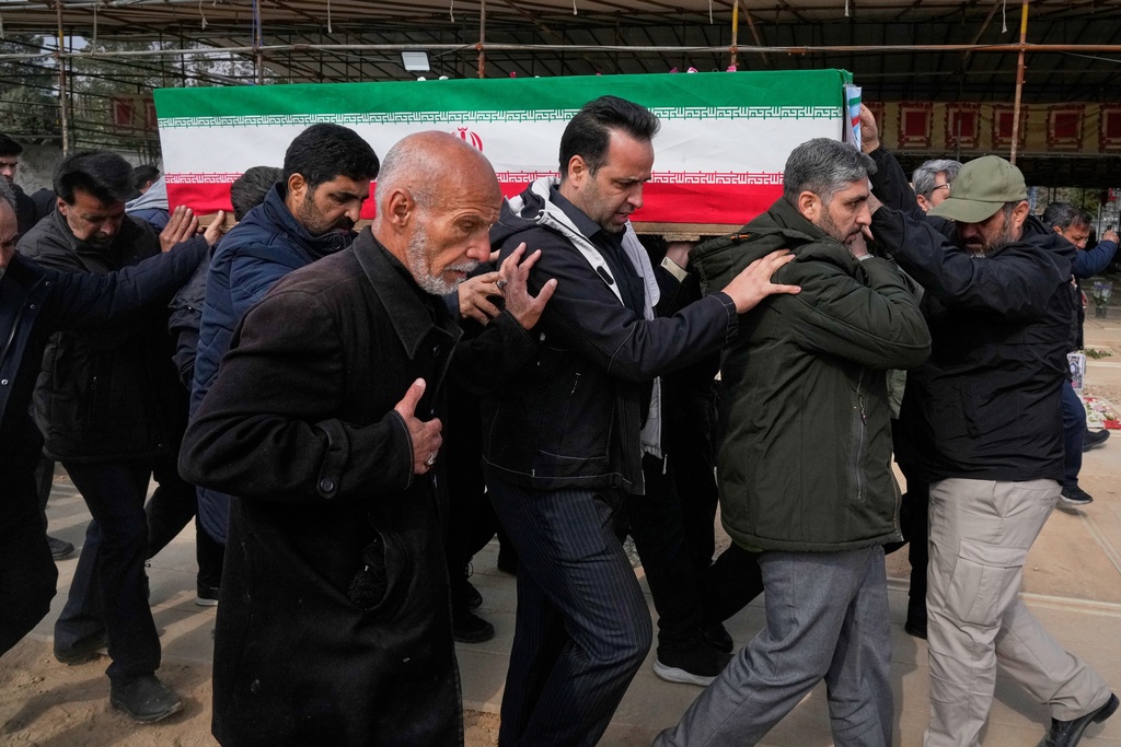 The coffin of Mehdi Hosseini, a man killed in a U.S.-Israeli strike, is carried for burial at Behesht-e Zahra cemetery in Tehran, Iran, Monday, March 9, 2026. (AP Photo/Vahid Salemi)