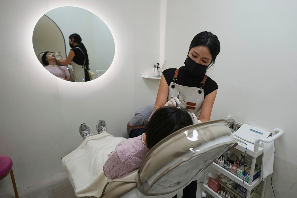 Kim Sho-yun, 45, who runs a cosmetic tattoo studio, draws a woman's eyebrow with pencil as she consults for semi-permanent cosmetic tattoos in Hanam, South Korea, Thursday, Sept. 18, 2025. (AP Photo/Lee Jin-man)