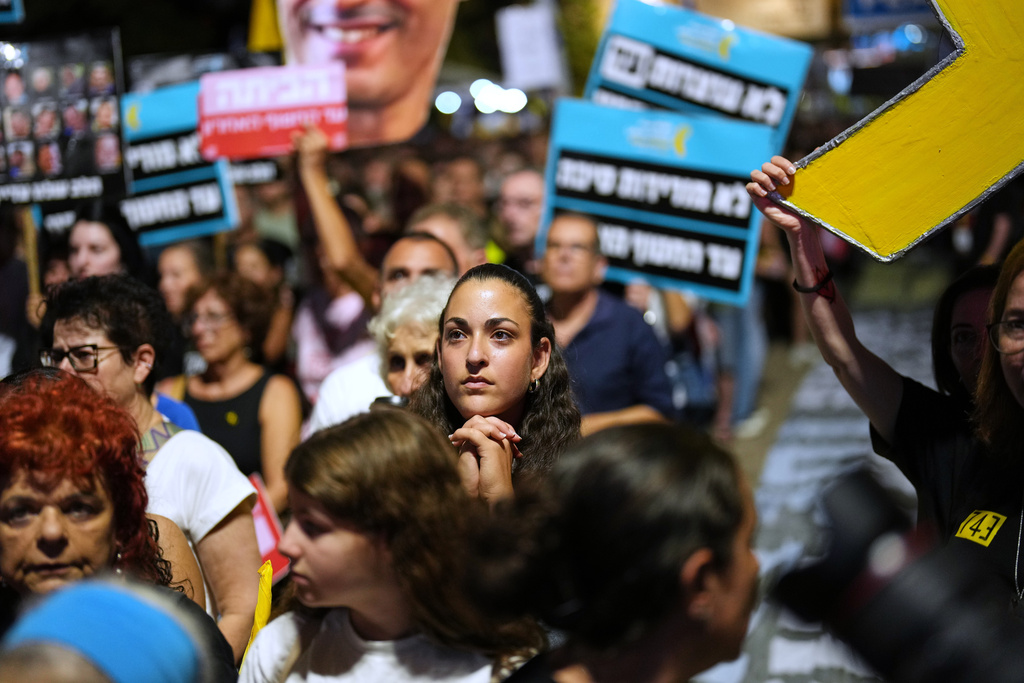 People listen to speeches as they take part in a rally demanding the returning of the bodies of hostages kidnapped by Hamas who are still in Gaza Strip, at a plaza known as hostages square, in Tel Aviv, Israel, Saturday, Oct. 18, 2025. (AP Photo/Francisco Seco)