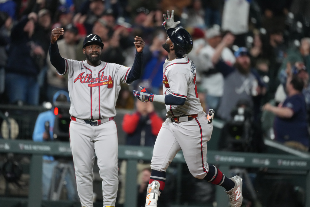 Atlanta Braves pinch hitter Michael Harris II, right, gestures as he circles the bases after hitting a two-run home run off Colorado Rockies relief pitcher Juan Mejia as Braves third base coach Tommy Watkins, left, reacts in the ninth inning of a baseball game Friday, May 1, 2026, in Denver. (AP Photo/David Zalubowski)